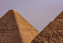 A close-up view of two iconic Egyptian pyramids under a clear blue sky.
