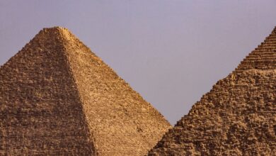 A close-up view of two iconic Egyptian pyramids under a clear blue sky.