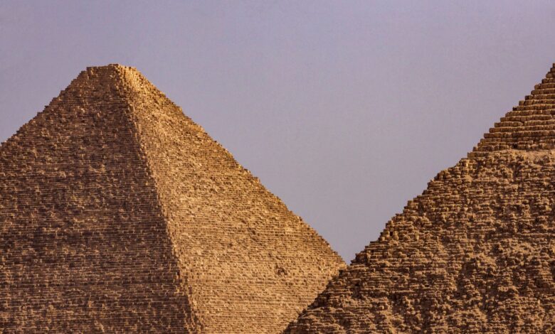 A close-up view of two iconic Egyptian pyramids under a clear blue sky.