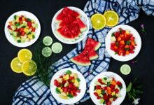 Top view of a vibrant and healthy fruit salad arrangement on a black background.