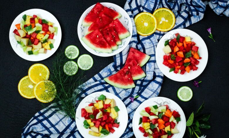 Top view of a vibrant and healthy fruit salad arrangement on a black background.