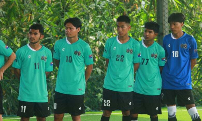 A group of young male soccer players in green jerseys standing outdoors in Myanmar.