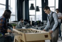 Office workers taking a break to play foosball in a modern startup environment.