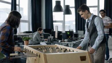 Office workers taking a break to play foosball in a modern startup environment.