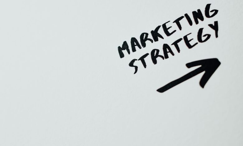 Close-up of handwritten 'Marketing Strategy' text with an arrow on white background.