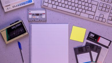An arrangement of retro office supplies featuring vintage electronics and media on a desk.