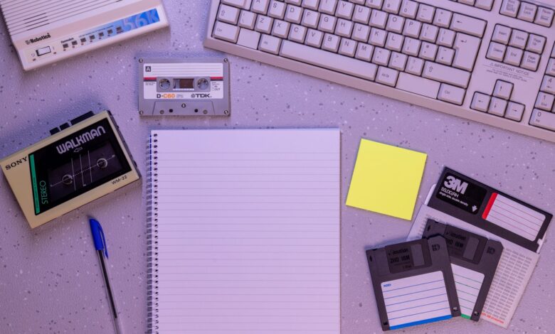 An arrangement of retro office supplies featuring vintage electronics and media on a desk.