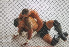 Two men engaged in a Brazilian Jiu-Jitsu training session inside a ring.