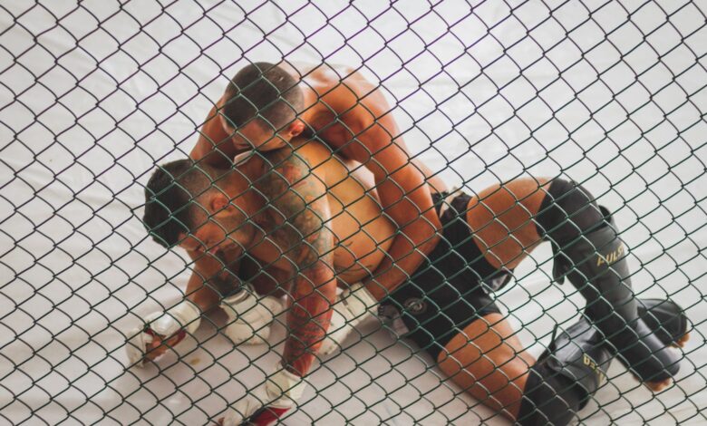 Two men engaged in a Brazilian Jiu-Jitsu training session inside a ring.
