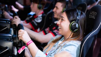 A group of people enjoying an immersive gaming experience at an e-sports center with headphones and steering wheels.