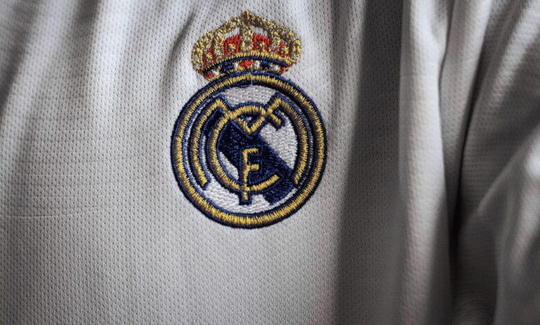 Detailed view of a famous embroidered logo on a white sports jersey fabric.