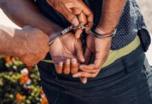 Close-up of a police officer handcuffing a man outdoors. Law enforcement in action.