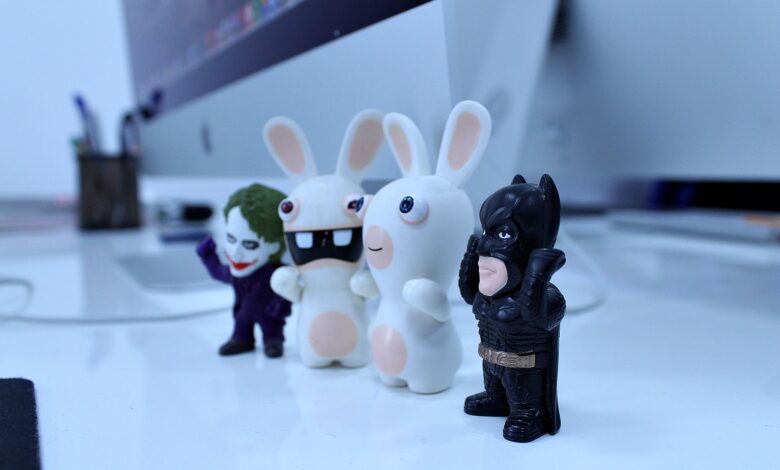 Close-up of various cartoon figurines on a modern desk setting, perfect for creativity-themed projects.