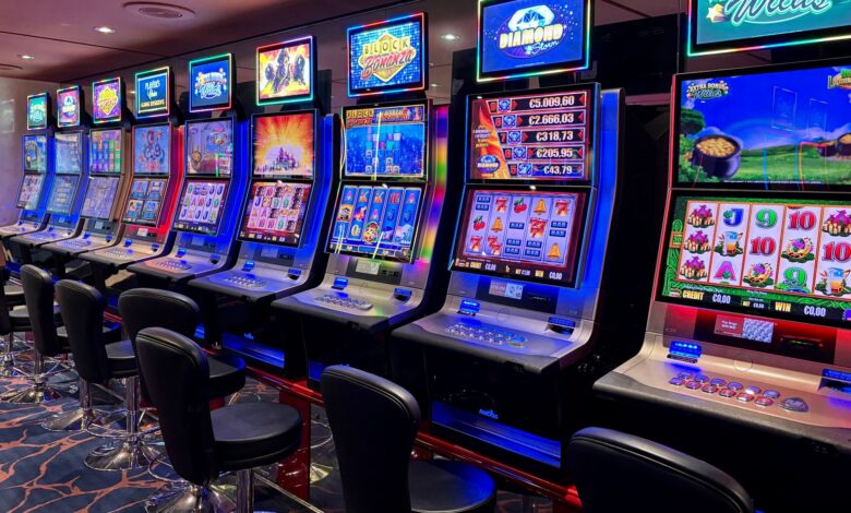 Bright casino slot machines with colorful displays and no people present.