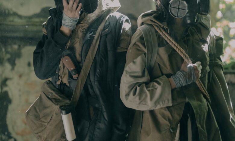 Two individuals in survival gear navigate a gritty urban post-apocalyptic setting.