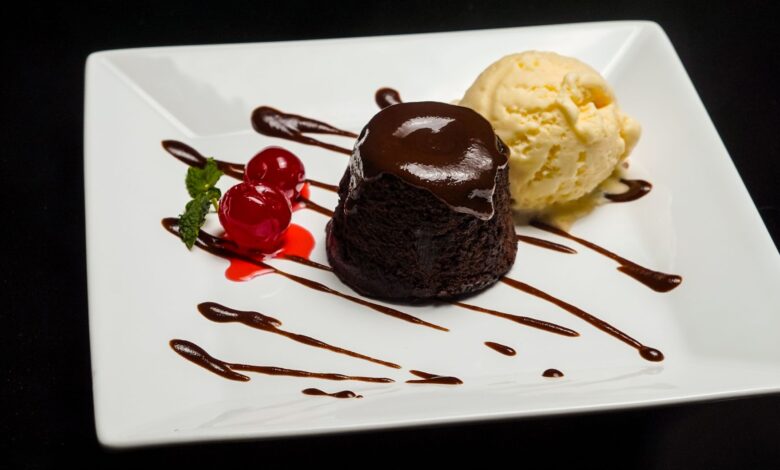 Delicious chocolate lava cake served with vanilla ice cream and cherries on a white plate.