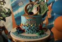 Vibrant Hot Wheels birthday cake with toy cars and a loop track, perfect for a child's party.