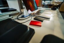 A neatly organized office desk featuring a laptop and several external hard drives, perfect for a digital workspace.