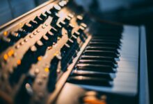 Detailed focus on a piano keyboard and control panel in a music studio setting.