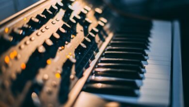 Detailed focus on a piano keyboard and control panel in a music studio setting.