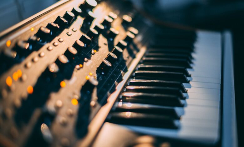Detailed focus on a piano keyboard and control panel in a music studio setting.