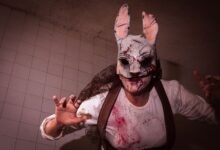 Close-up of a person in a bloody rabbit mask with ominous lighting.
