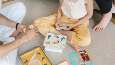 A family enjoying educational puzzles and card games together on a cozy carpet.