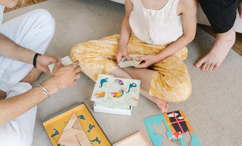 A family enjoying educational puzzles and card games together on a cozy carpet.