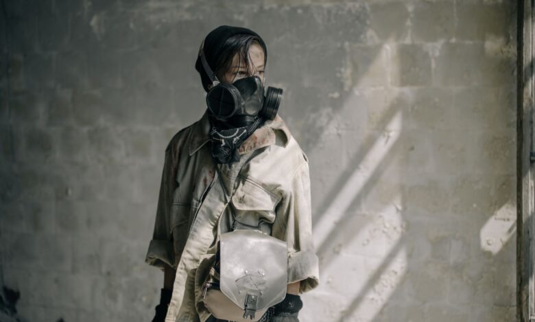 A young person with a gas mask stands in a dilapidated building, evoking a post-apocalyptic scene.