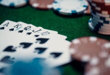 Close-up of a royal flush poker hand surrounded by colorful chips on a green table.