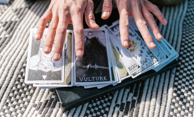 Close-up of hands on tarot cards, suggestive of divination or spiritual guidance.