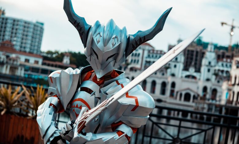 A person in futuristic armor with a sword posing outdoors, showcasing cosplay artistry.