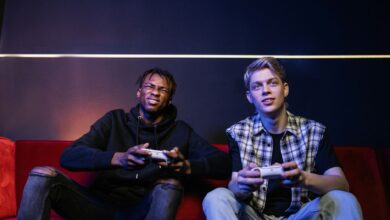 Two young men enjoying video games together on a couch, capturing leisure and friendship.