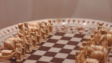 Close-up of a handcrafted wooden chess set with detailed figures on a beautifully decorated board.