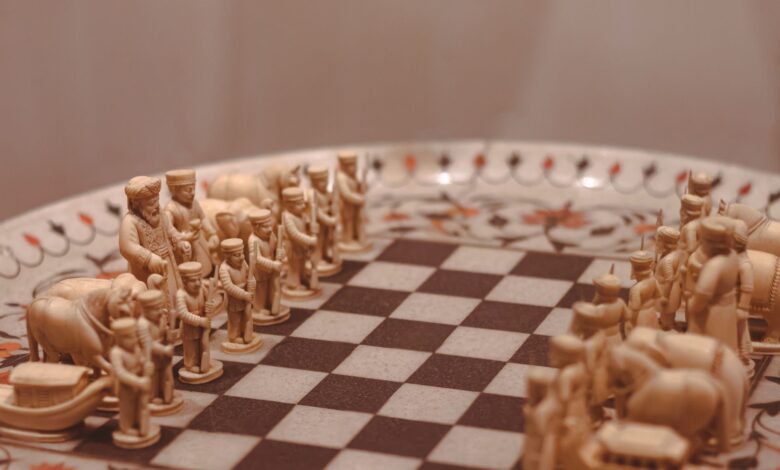 Close-up of a handcrafted wooden chess set with detailed figures on a beautifully decorated board.