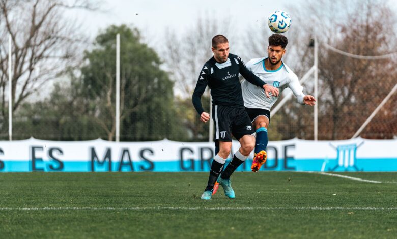 Two soccer players in action during an intense match, competing for the ball outdoors.