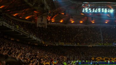Exciting night soccer game with packed cheering fans and vibrant stadium lights.