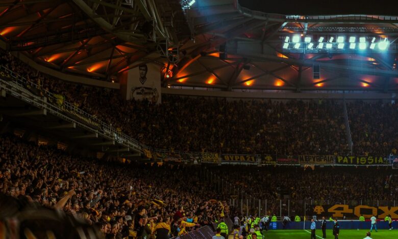 Exciting night soccer game with packed cheering fans and vibrant stadium lights.