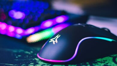 A close-up of a colorful gaming mouse and illuminated RGB keyboard, perfect for tech setups.
