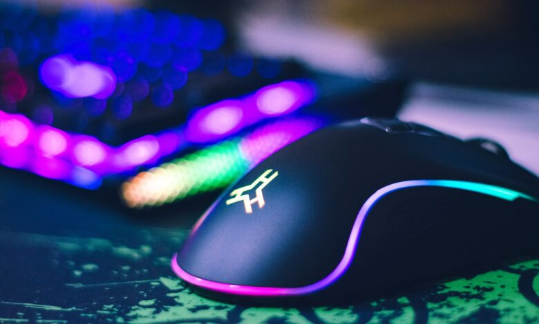 A close-up of a colorful gaming mouse and illuminated RGB keyboard, perfect for tech setups.