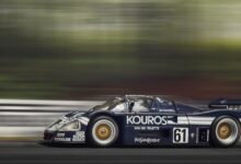 A sleek race car speeds around the track, showcasing motion blur and dynamic movement.