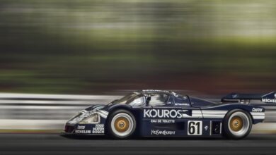 A sleek race car speeds around the track, showcasing motion blur and dynamic movement.