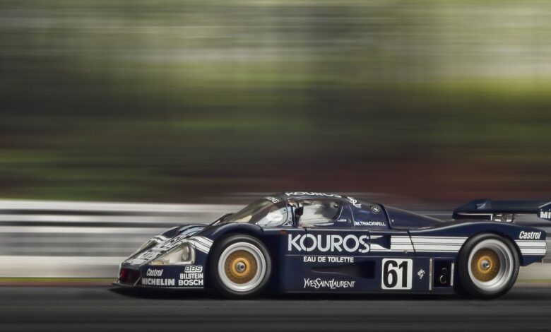 A sleek race car speeds around the track, showcasing motion blur and dynamic movement.
