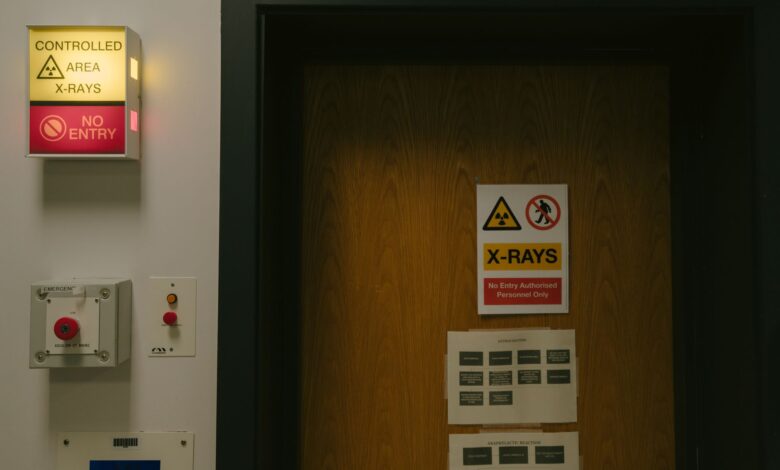 Warning signs on a wooden door indicating a controlled X-ray area with no entry restriction.