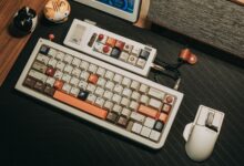 Custom mechanical keyboard and mouse setup on a wooden desk with a retro aesthetic.