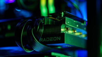 Detailed close-up of a gaming PC's Radeon graphics card with vibrant RGB lighting, showcasing cables and hardware.