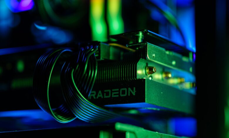 Detailed close-up of a gaming PC's Radeon graphics card with vibrant RGB lighting, showcasing cables and hardware.
