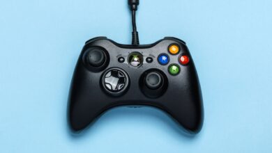 Black video game controller isolated on a blue background for gaming enthusiasts.