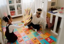 Joyful siblings have fun playing pretend knights in handmade costumes indoors.