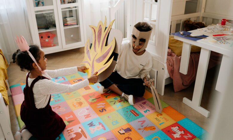 Joyful siblings have fun playing pretend knights in handmade costumes indoors.